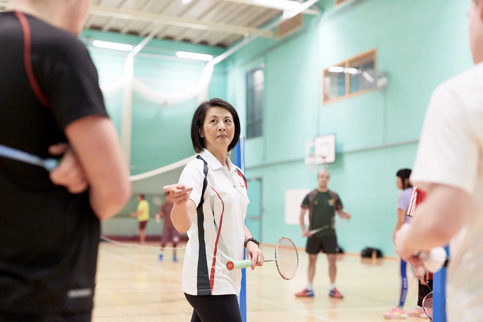 Linda talking with players during a badminton coaching session